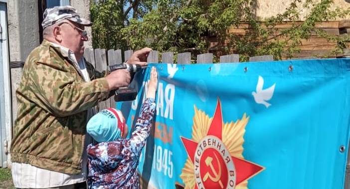 Жители Ленинского района проводят мастер-классы по изготовлению брошей из георгиевских лент и украшают улицы и свои дома к празднику 