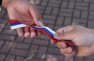 Жителям Барнаула вручают ленты в цветах российского флага в честь праздника